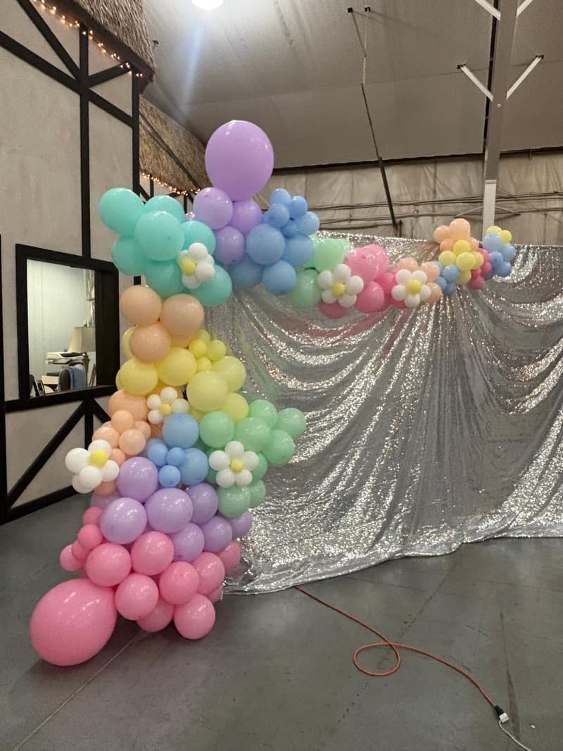 Blush and gold organic balloon arch installation in a modern bright room